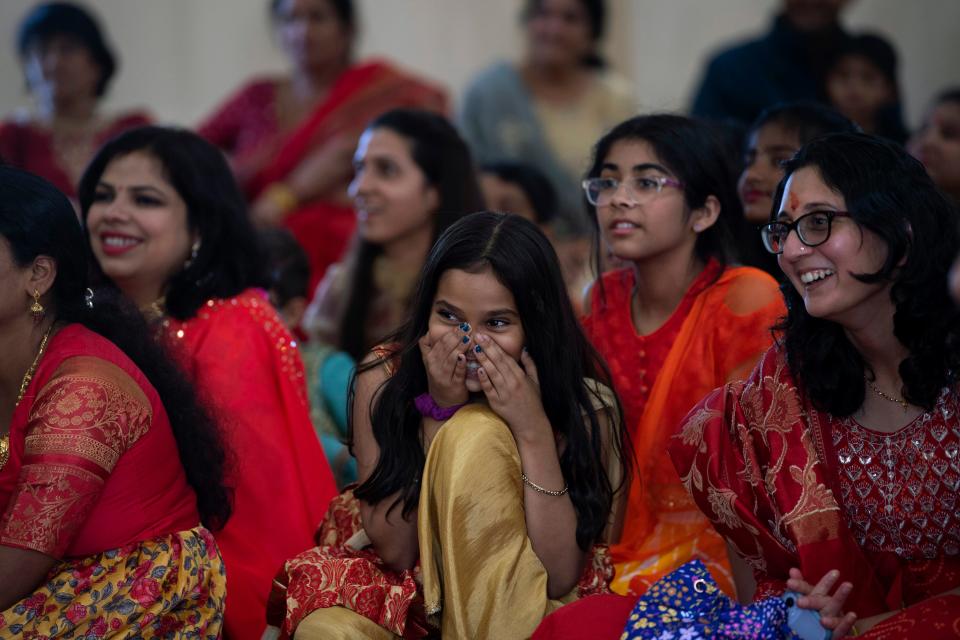 Saanvi Mishra, 10, center, tries to conceal her laughter during a skit at the Tri-State Hindu Temple in Newburgh, Ind., Saturday afternoon, Oct. 15, 2022. The temple's young people were singing, dancing and acting as part of the 3-day Prana Pratishtha festival.
