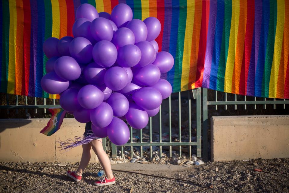A woman holds balloons as she participates in the first Gay Pride Parade in Beersheba, Israel, Thursday, June 22, 2017.