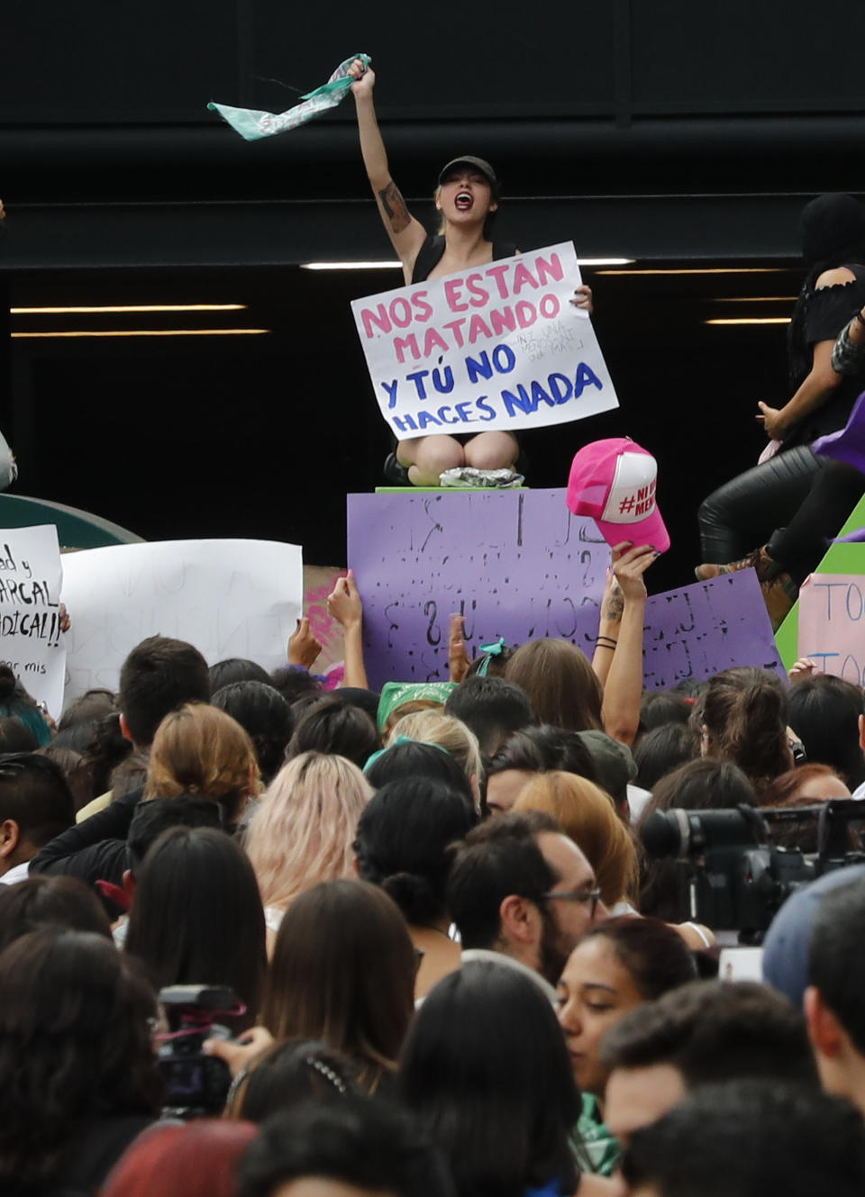 A woman holds a sign with a message that reads in Spanish: "They are killing us, and you do nothing" during a protest march demanding justice and for their safety, sparked by two recent alleged rapes by police, in Mexico City, Friday, Aug. 16, 2019. (AP Photo/Marco Ugarte)