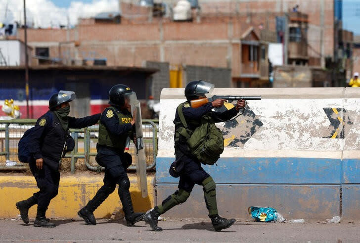 Oficiales de policía peruanos operan mientras los manifestantes realizan una protesta exigiendo elecciones anticipadas y la liberación del expresidente peruano Pedro Castillo, en Juliaca, Perú