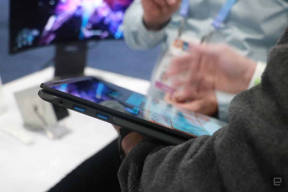 The LG Gram Pro 2-in-1 folded with its screen facing up, resting on a person's arm as the other hand interacts with the display.