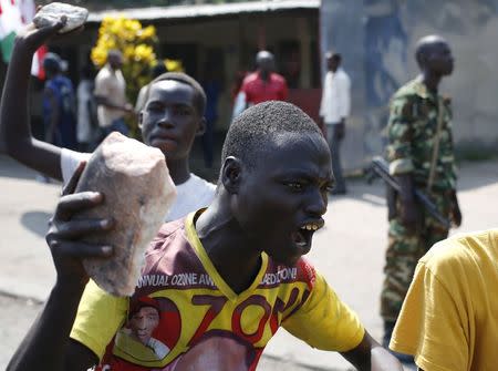 A protester gestures with a stone during a protest against President Pierre Nkurunziza's decision to run for a third term in Bujumbura, Burundi, May 29, 2015. REUTERS/Goran Tomasevic