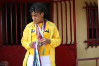 Guinean wrestler Fatoumata Yarie Camara holds past credentials and medals at her house in Conakry, Guinea, Monday July 19, 2021. A West African wrestler's dream of competing in the Olympics has come down to a plane ticket. Fatoumata Yarie Camara is the only Guinean athlete to qualify for these Games. She was ready for Tokyo, but confusion over travel reigned for weeks. The 25-year-old and her family can't afford it. Guinean officials promised a ticket, but at the last minute announced a withdrawal from the Olympics over COVID-19 concerns. Under international pressure, Guinea reversed its decision. (AP Photo/Youssouf Bah)