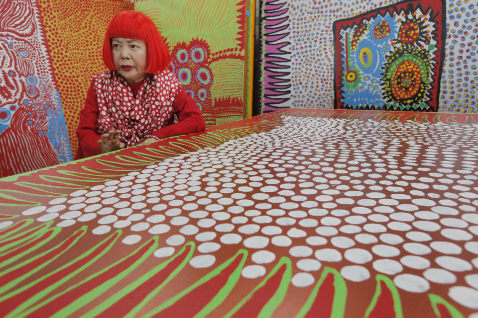 In this photo taken Wednesday, Aug. 1, 2012, Japanese avant-garde artist Yayoi Kusama speaks during an interview at her studio, filled with wall-sized paintings throbbing with her repetitive dots, in Tokyo. Kusama's signature splash of dots has now arrived in the realm of fashion in a new collection from French luxury brand Louis Vuitton - bags, sunglasses, shoes and coats. The latest Kusama collection is showcased at its boutiques around the world, including New York, Paris, Tokyo and Singapore, sometimes with replica dolls of Kusama. (AP Photo/Itsuo Inouye)