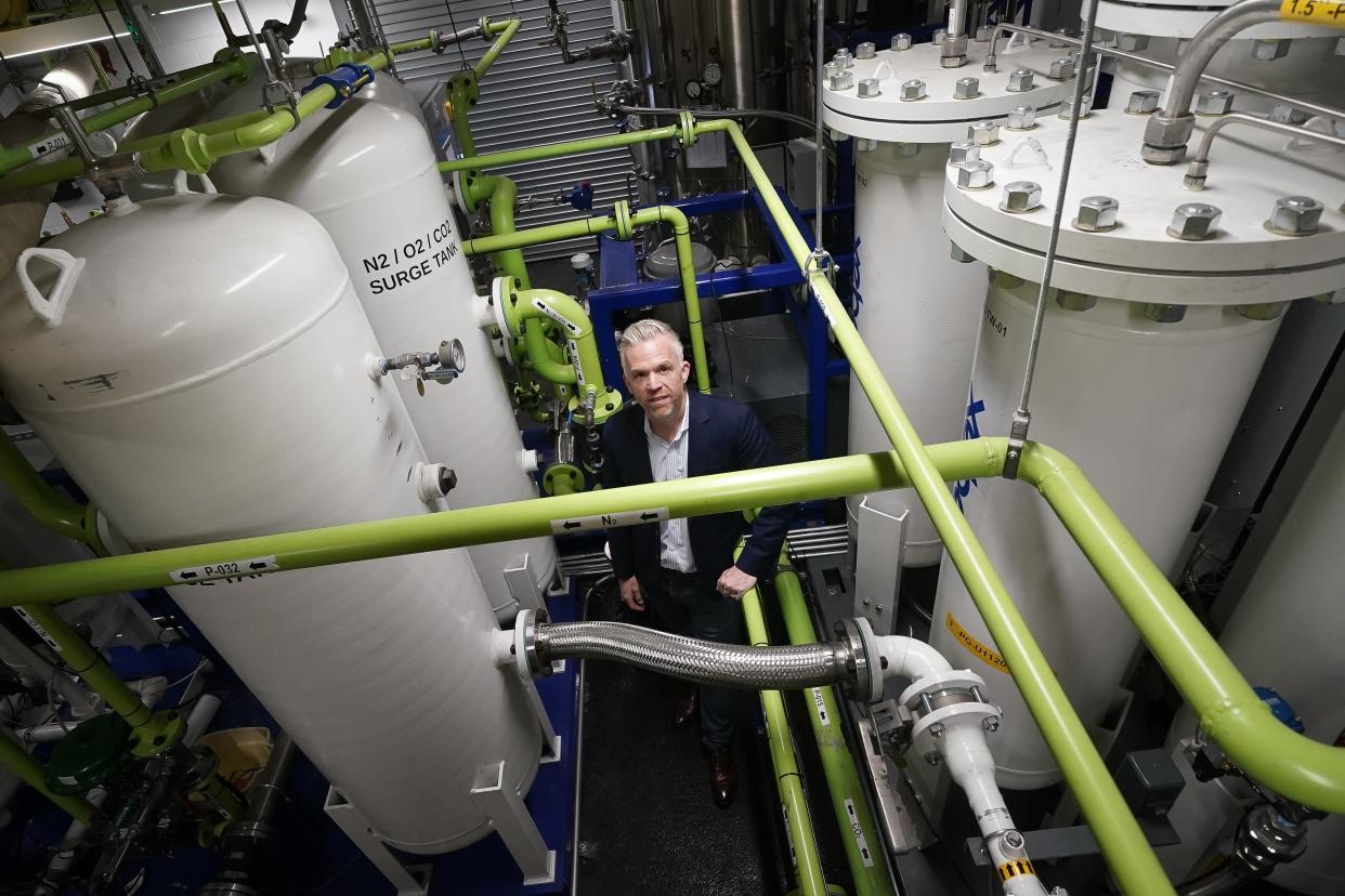 Brian Asparro, chief operating officer of CarbonQuest, stands in a production room where liquid carbon dioxide is converted from a byproduct of a natural gas fired water boiler to a salable industrial product, Tuesday, April 18, 2023, in New York. New York is forcing buildings to clean up, and several are experimenting with capturing carbon dioxide that is emitted, cooling it into a liquid and mixing it into concrete where it turns into a mineral. (AP Photo/John Minchillo)