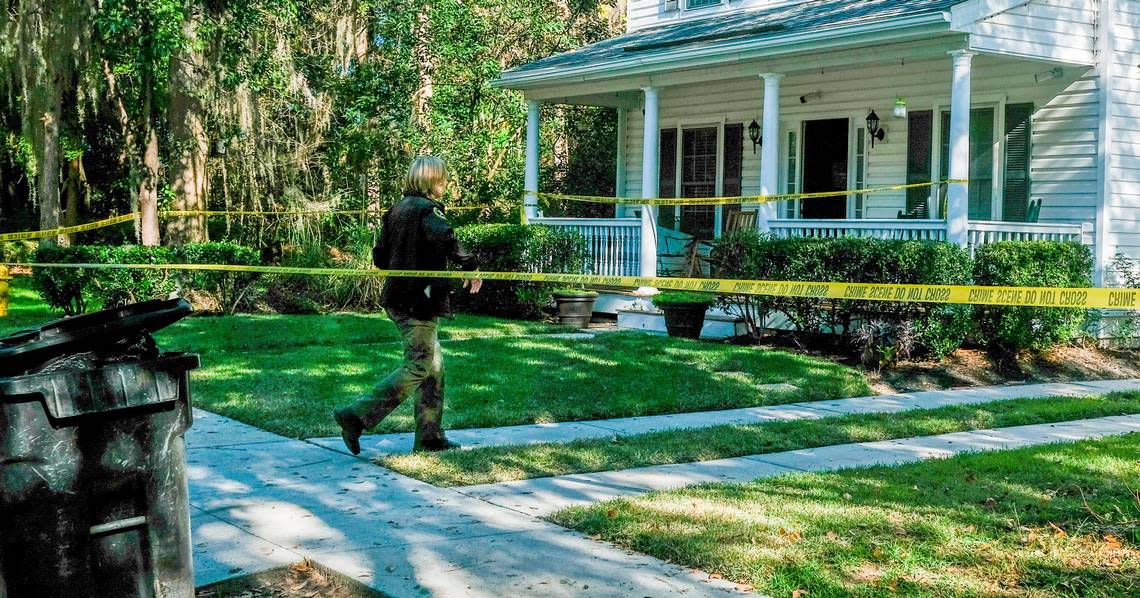 Security cameras cover the entrance of the home as a deputy with the Beaufort County Sheriff’s Office walks under the police tape on Tuesday, Nov. 17, 2020 at a homicide investigation in the gated-community of Westbury Park in Bluffton. Police responded to the neighborhood on Monday night after receiving a call of shots fired and found 45-year-old Timothy Milliken dead. As police were working inside the home on Tuesday, a deputy turned away a garbage man from emptying the receptacle, foreground, outside of Milliken’s home.