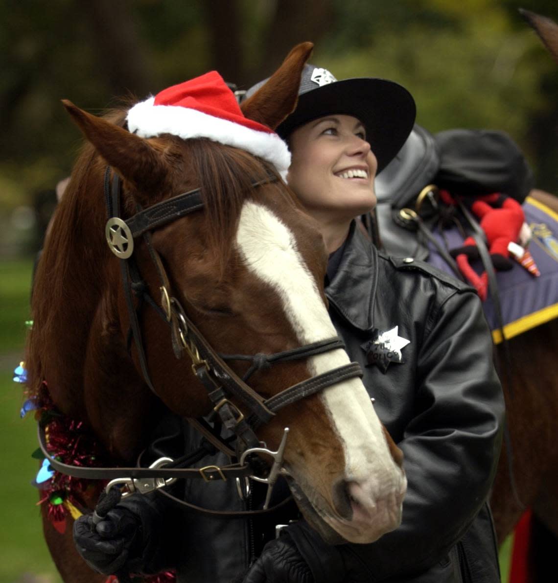 Sacramento mounted police officer LuAnne Holmsen holds her horse Ted, wearing Christmas attire, after participating in the 21st Santa Parade in downtown Sacramento in 2003. Hector Amezcua/Sacramento Bee file