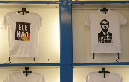 T-shirts, one with message against Presidential candidate Jair Bolsonaro reading "Not Him" (L) and the other on his support depicting his face, are displayed at a cloth stamping store in Rio de Janeiro, Brazil October 17, 2018. REUTERS/Ricardo Moraes