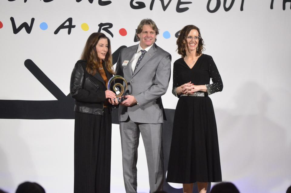 Susanna Tanner, owner of Susanna Tanner Photography receives the Champion of Diversity award from 2024 Chamber Board Chair Ron Holbrook and Chamber President and CEO Melissa Vance for her 