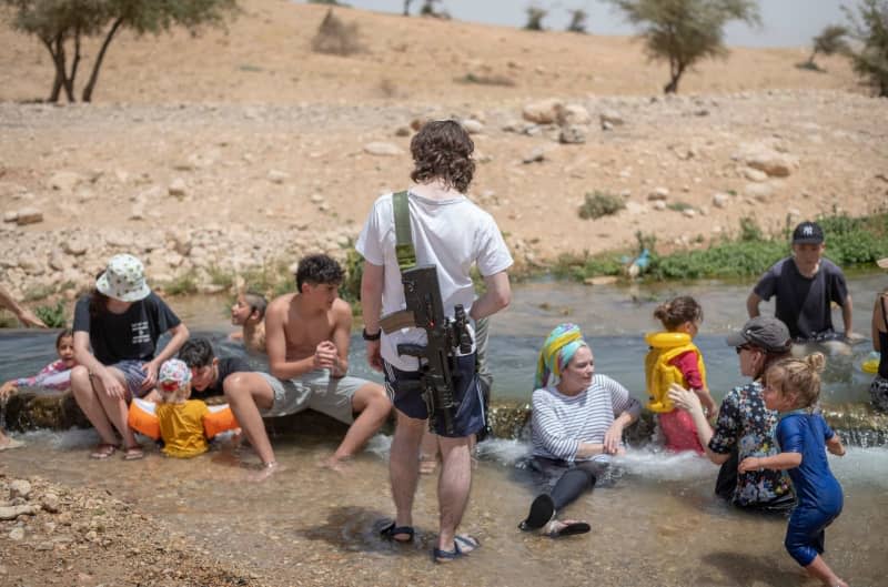 Israeli settlers swim in a mountain spring overlooking the Jordan valley near the Palestinian village of Duma during high heat in the region. Ilia Yefimovich/dpa