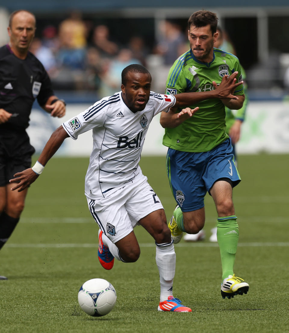SEATTLE, WA - AUGUST 18: Dane Richards #20 of the Vancouver Whitecaps dribbles against Brad Evans #3 of the Seattle Sounders FC at CenturyLink Field on August 18, 2012 in Seattle, Washington. (Photo by Otto Greule Jr/Getty Images)
