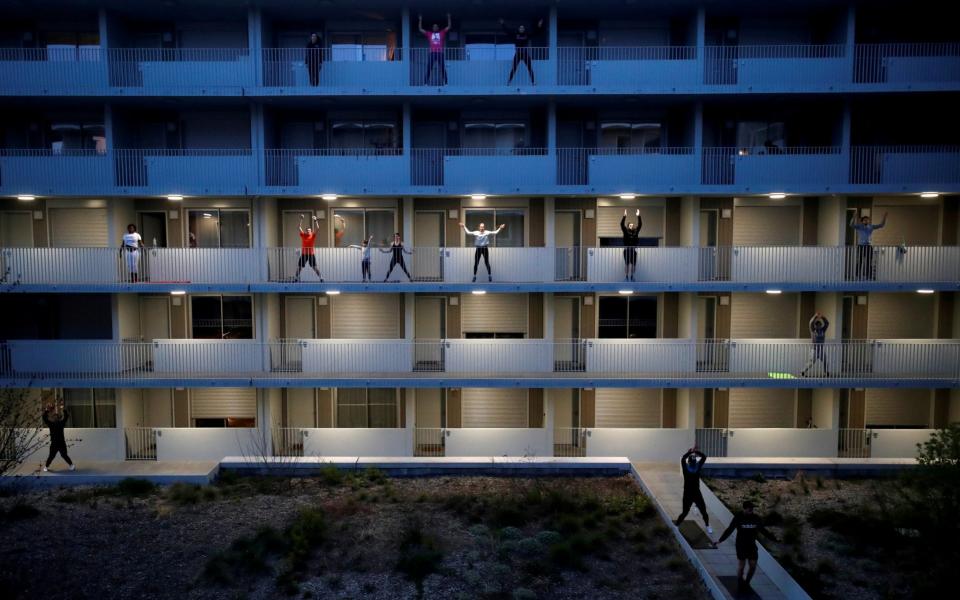 Residents exercise on their balconies in Nantes, France, as the nationwide lockdown is extended - REUTERS