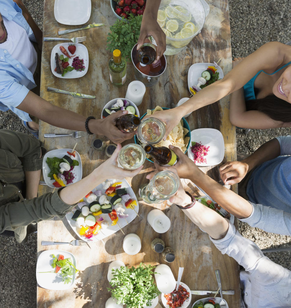 Overhead view friends toasting wine glasses patio table