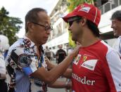 Property tycoon Ong Beng Seng (L), credited as one of the key people responsible for bringing the Formula One to Singapore, greets Ferrari Formula One driver Felipe Massa of Brazil during the Singapore F1 Grand Prix at the Marina Bay street circuit in Singapore September 22, 2013. REUTERS/Tim Chong (SINGAPORE - Tags: SPORT MOTORSPORT F1 BUSINESS)