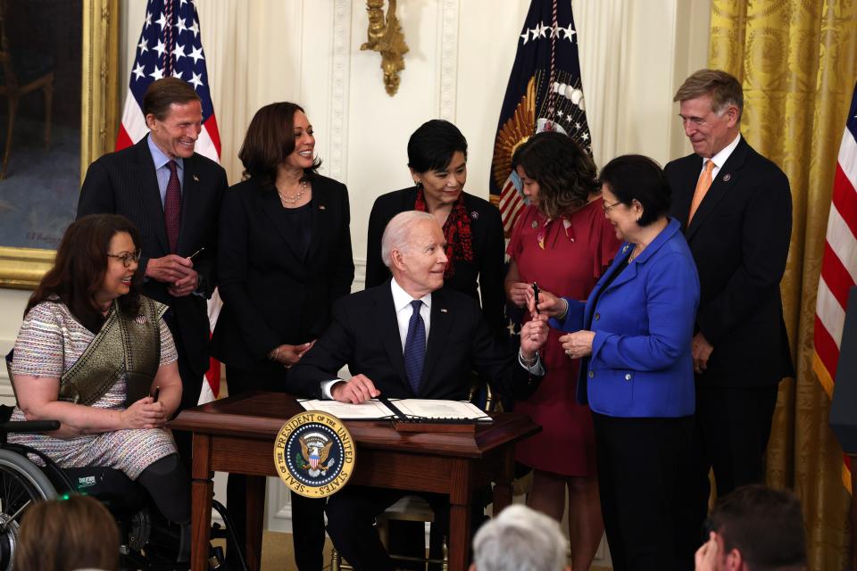 President Joe Biden hands a pen to Sen. Mazie Hirono, D-Hawaii, after signing the COVID-19 Hate Crimes Act into law May 20. Joining them at the White House for the signing are, from left, Sen. Tammy Duckworth, D-Ill.; Sen. Richard Blumenthal, D-Conn.; Vice President Kamala Harris; Rep. Judy Chu, D-Calif.; Rep. Grace Meng, D-N.Y.; and Rep. Don Beyer, D-Va. The legislation, drafted in response to violence against the Asian American and Pacific Islander (AAPI) community during the coronavirus pandemic, will create a position in the Department of Justice to focus on the rise in hate crimes and provide resources to federal, state and local jurisdictions to better report cases.