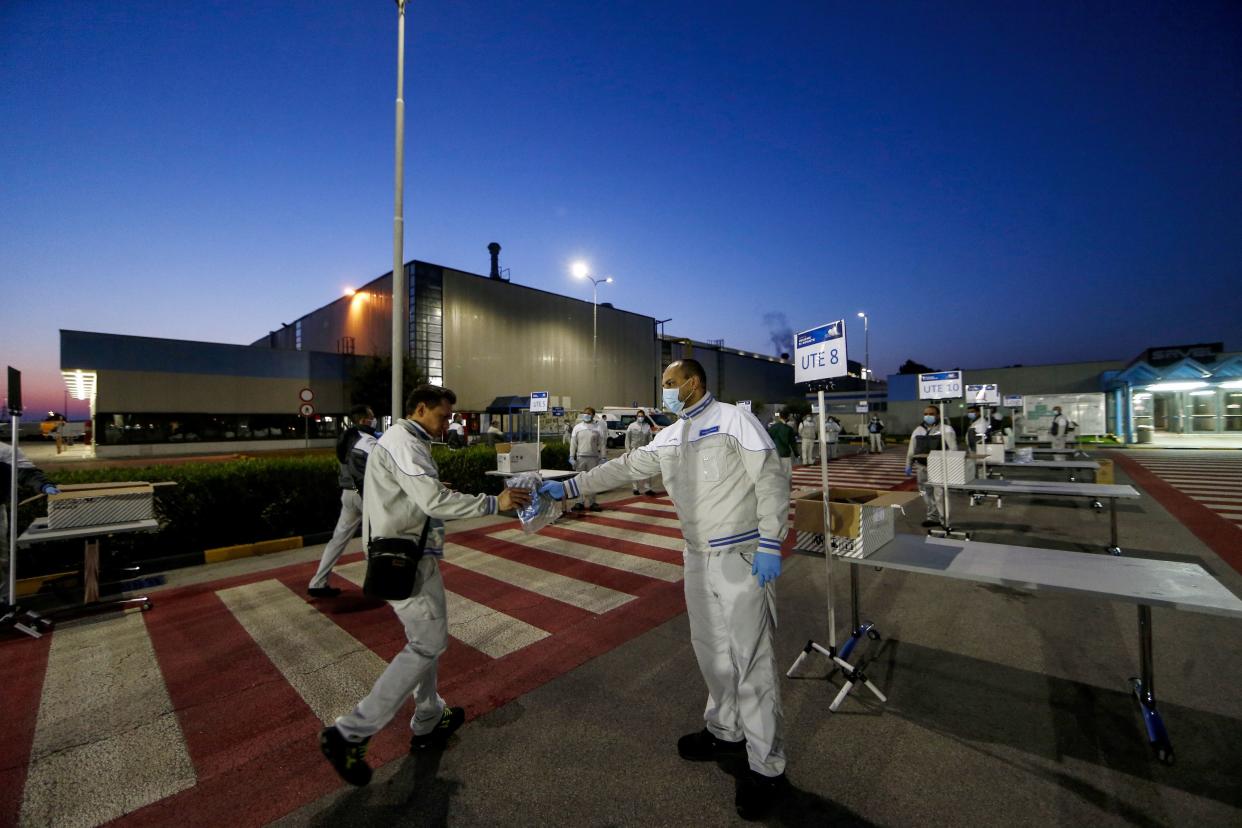 Safety kits with rubber gloves and face masks are distributed to workers at the entrance of the Fiat Chrysler Automobiles plants of Atessa, in Central Italy on Monday, April 27, 2020. FCA is partially reopening factories all over Italy after the lockdown due to the coronavirus outbreak.