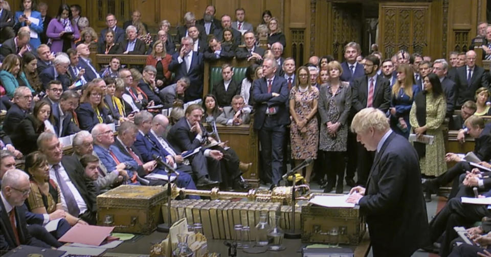 Britain's Prime Minister Boris Johnson delivers a statement to lawmakers inside a crowded House of Commons in London, Saturday Oct. 19, 2019. At a rare weekend sitting of Parliament, Johnson implored legislators to ratify the Brexit deal he struck this week with the other 27 EU leaders. (House of Commons via AP)