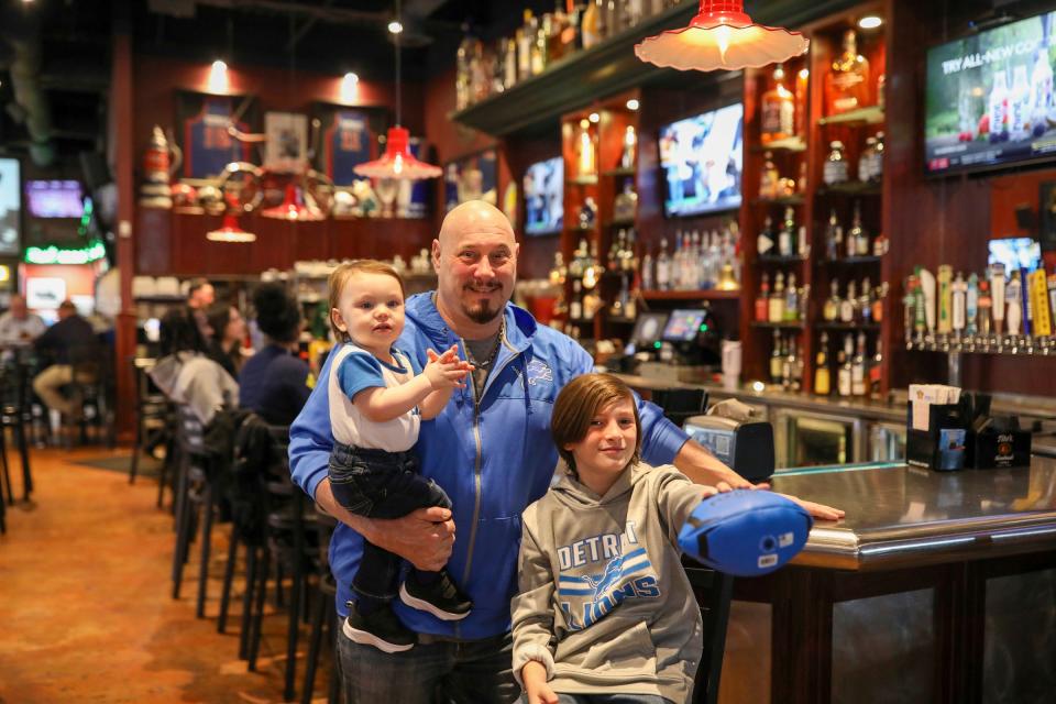 Steve Mallie, 55, holds his 1-year-old son Parker, standing next to his other son Gavin Mallie, 11, all of Trenton, at his bar Mallie’s Sports Grill and Bar in Southgate, Mich. on Friday, Jan. 5, 2024.