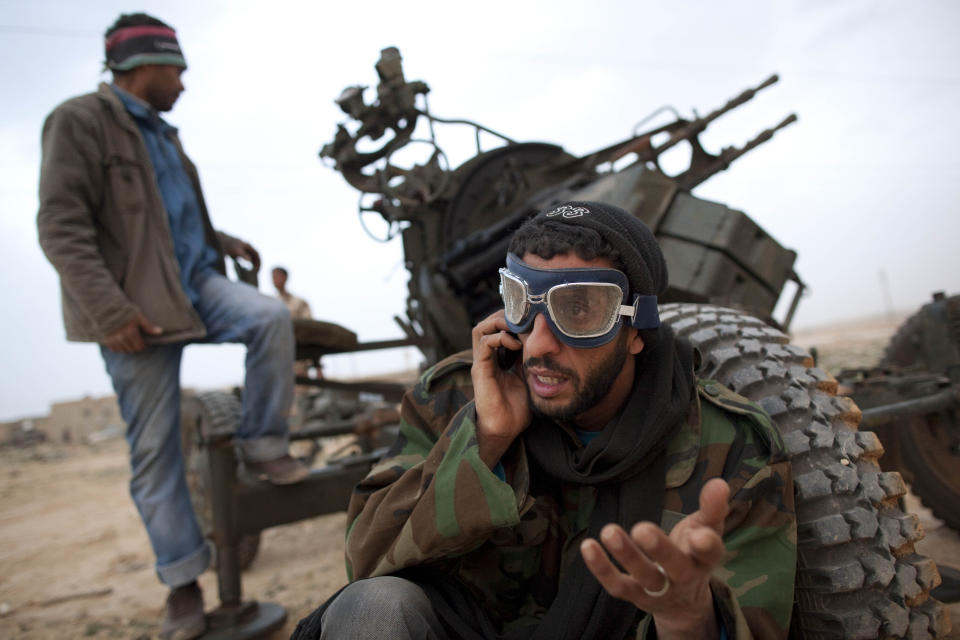 FILE - in this March 4, 2011 file photo, Libyan rebels who are part of the forces against Libyan leader Moammar Gadhafi stand with an anti-aircraft gun as they prepare to fight on the front-line near Ras Lanuf, west of the town of Brega, eastern Libya. Ten years ago, an uprising in Tunisia opened the way for a wave of popular revolts against authoritarian rulers across the Middle East known as the Arab Spring. For a brief window as leaders fell, it seemed the move toward greater democracy was irreversible. Instead, the region saw its most destructive decade of the modern era. (AP Photo/Kevin Frayer, File)