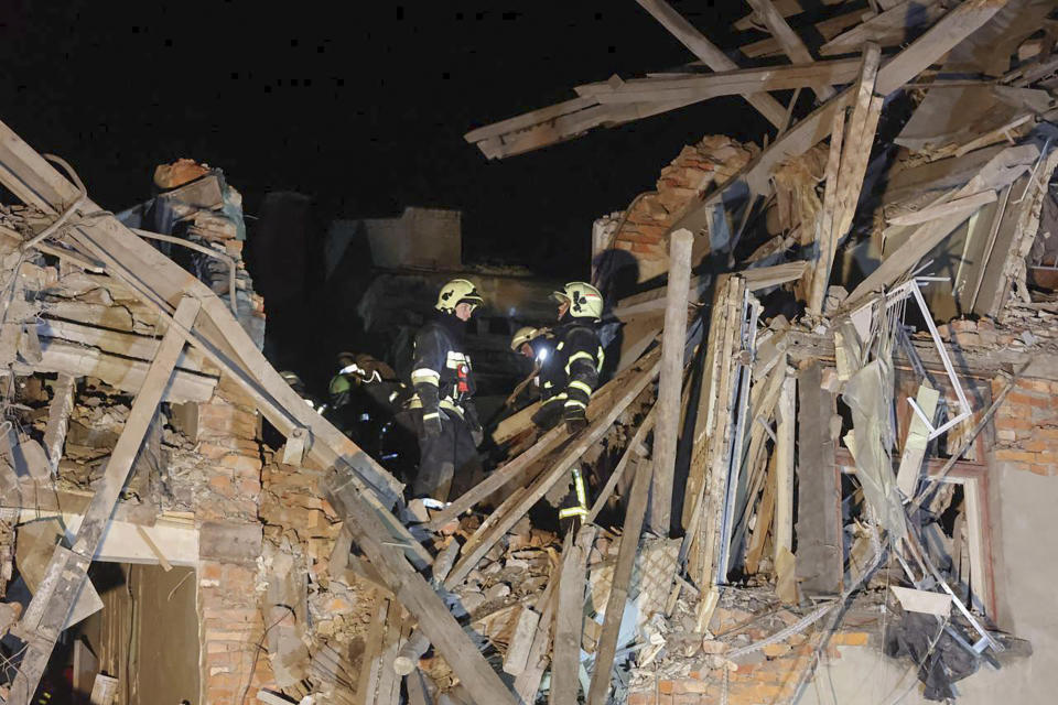 In this photo provided by Kharkiv Regional Administration, emergency workers work in an apartment house damaged in Russian rocket attack is seen in Kharkiv, Ukraine, in the early hours of Wednesday, Jan. 17, 2024. (Kharkiv Regional Administration via AP)