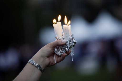 Una mujer sostiene unas velas durante una ceremonia a las víctimas de la matanza de Aurora, el 22 de julio de 2012 en EEUU.