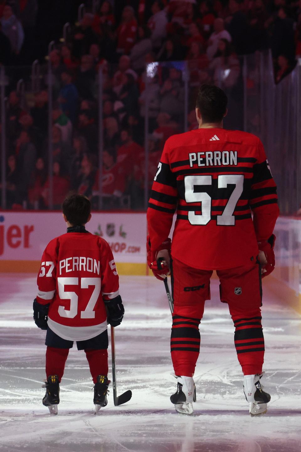 David Perron (57) of the Detroit Red Wings stands with his son for the National Anthem prior to playing the Carolina Hurricanes after a ceremony celebrating his 1000th career NHL game at Little Caesars Arena on December 13, 2022 in Detroit, Michigan.