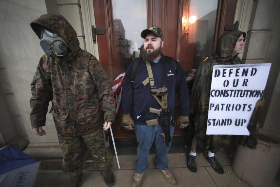 Protesters stand at the doors of the State Capitol during a rally against Michigan’s coronavirus stay-at-home order in Lansing, Mich., Thursday, May 14, 2020. (AP Photo/Paul Sancya)