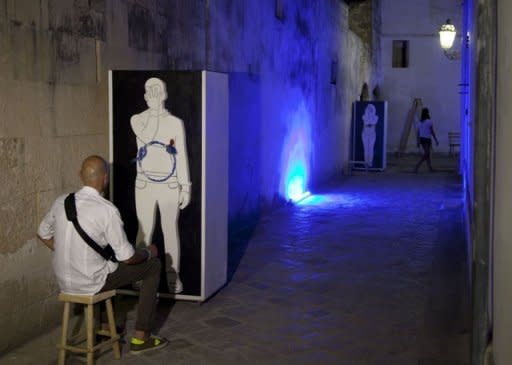 A man sits in front of an installation that is part of a philosophy experiment in Corigliano d'Otranto. Philosophers believe that Italy's real problem was not the economic crisis but "the crisis in the relationship between man and his surroundings"