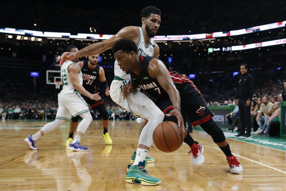 Miami Heat's Kyle Lowry (7) drives past Boston Celtics' Jayson Tatum during the first half of Game 3 of the NBA basketball playoffs Eastern Conference finals Saturday, May 21, 2022, in Boston. (AP Photo/Michael Dwyer)