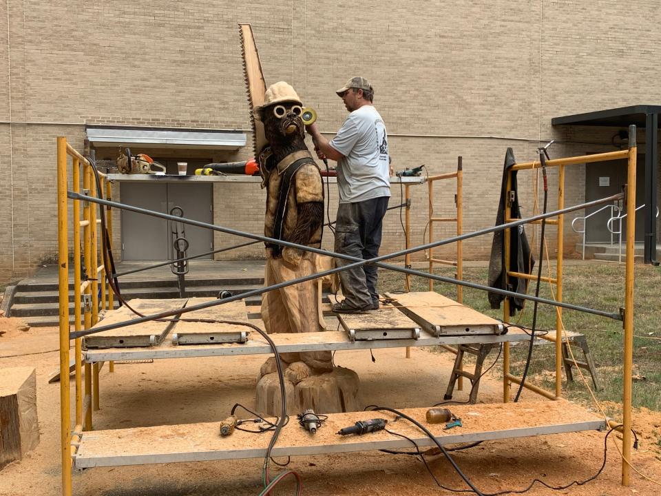 Dayton Scoggins works on a construction worker bear statue outside Thalia Mara Hall in Jackson for the 2023 Great Delta Bear Affair in Rolling Fork.