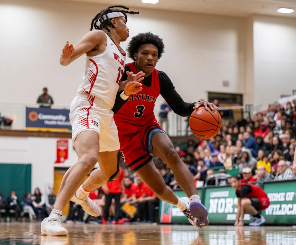 North Central High School senior Jaxson Bell (3) drives the ball into the defense of Lawrence North High School junior Davion Hampton (12) during the first half of an IHSAA Class 4A Boys’ Sectional basketball game, Wednesday, Feb. 28, 2024, at Lawrence North High School.