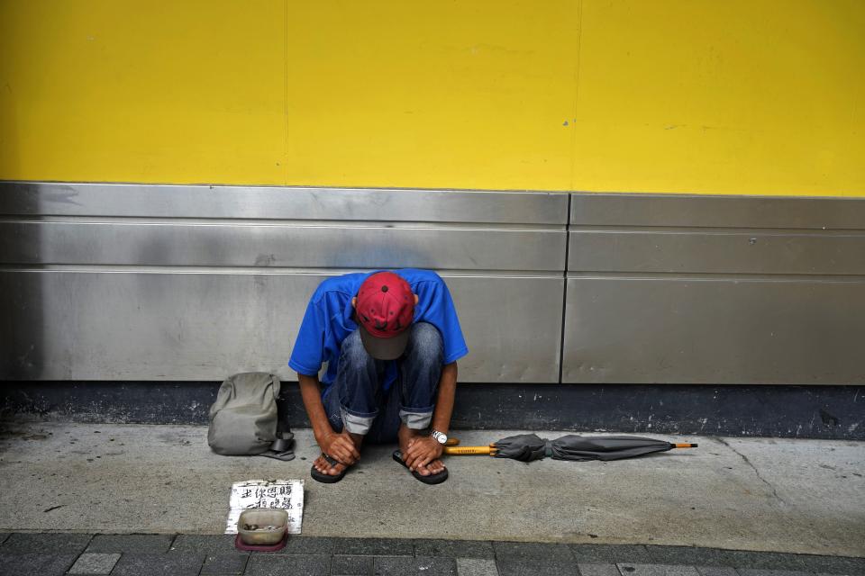 A beggar is seen at a downtown street in Hong Kong Tuesday, June 29, 2021. A year after Beijing imposed a harsh national security law on Hong Kong, the civil liberties that raised hopes for more democracy are fading.(AP Photo/Vincent Yu)