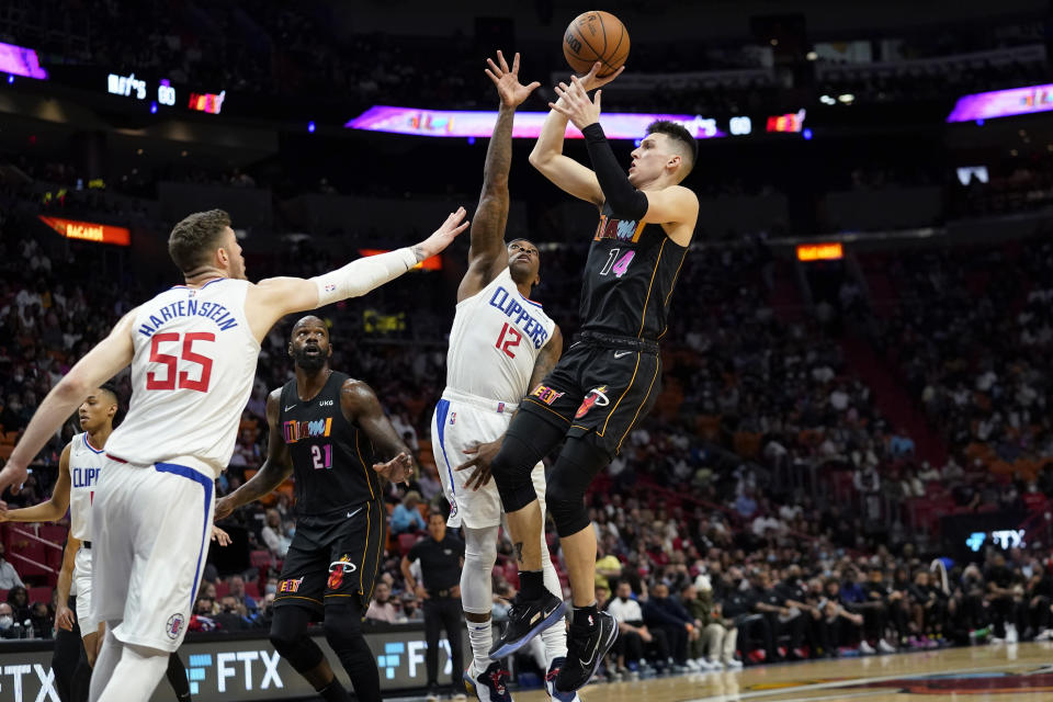 Miami Heat guard Tyler Herro (14) goes to the basket and Los Angeles Clippers center Isaiah Hartenstein (55) and guard Eric Bledsoe (12) defend during the first half of an NBA basketball game, Friday, Jan. 28, 2022, in Miami. (AP Photo/Lynne Sladky)