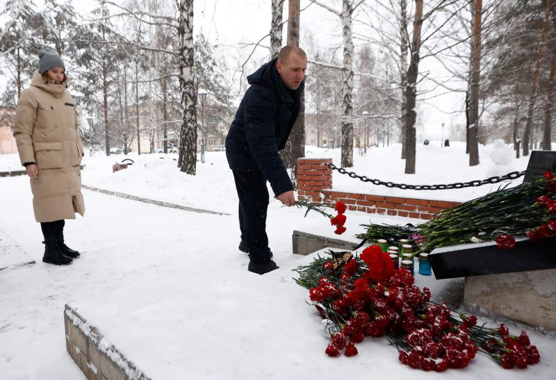 People lay flowers at the Alley of Miners' Glory to pay tribute to the miners and rescuers killed in an accident at the Listvyazhnaya coal mine in Kemerovo region