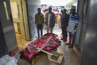 Relatives wait to collect the bodies of villagers who were killed by suspected rebels as they retreated from Saturday's attack on the Lhubiriha Secondary School, outside the mortuary of the hospital in Bwera, Uganda Sunday, June 18, 2023. Ugandan authorities have recovered the bodies of 41 people including 38 students who were burned, shot or hacked to death after suspected rebels attacked the school in Mpondwe near the border with Congo, according to the local mayor. (AP Photo/Hajarah Nalwadda)