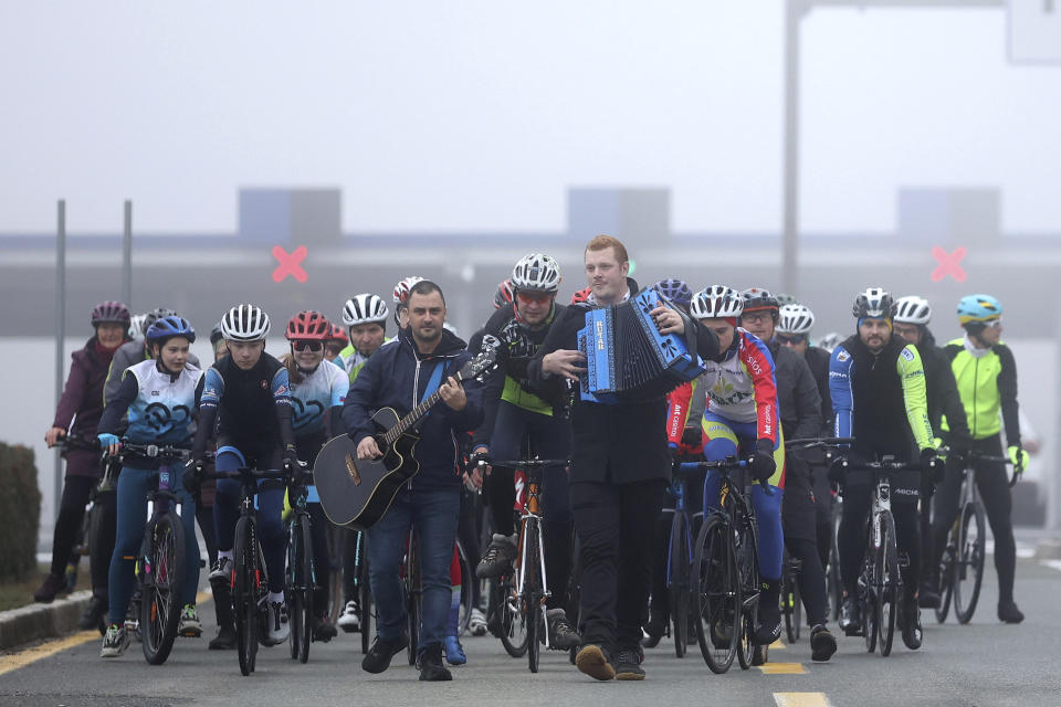 A group of Slovenian cyclists crosses the Rupa border between Croatia and Slovenia for the first time without any interruptions, Croatia, Sunday, Jan. 1, 2023. At the stroke of midnight on Saturday, Croatia switched to the shared European currency, the euro, and removed dozens of border checkpoints to join the world's largest passport-free travel area, completing a dream conceived 30 years ago when it fought a war for independence from Yugoslavia in which 20,000 people were killed and hundreds of thousands displaced. (AP Photo/Armin Durgut)