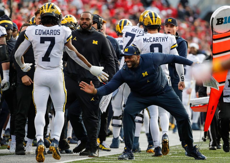 Michigan co-offensive coordinator Sherrone Moore high fives running back Donovan Edwards (7) after Edwards's scored a touchdown against Ohio State during the second half Nov. 26, 2022 at Ohio Stadium in Columbus.