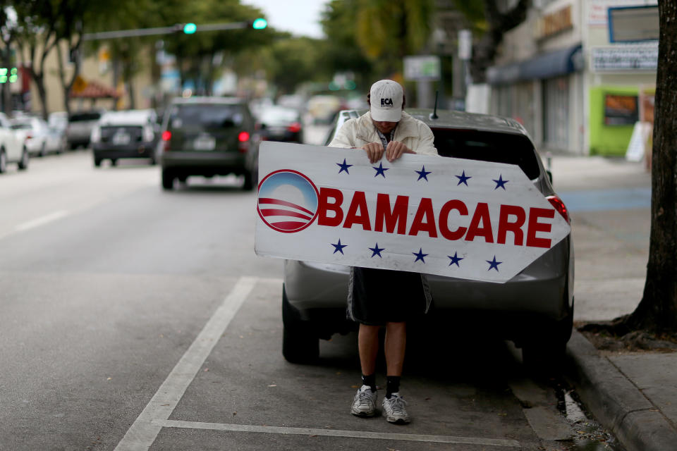 Pedro Rojas holds a sign directing people to an insurance company where they can sign up for the Affordable Care Act. (Photo by Joe Raedle/Getty Images) 