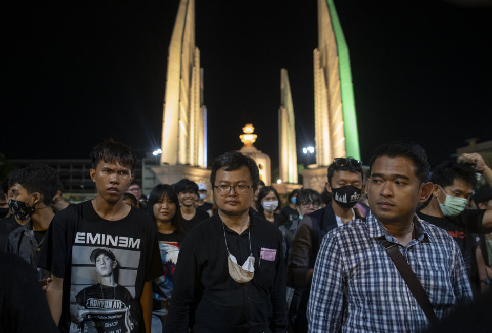 Pro-democracy activist and human rights lawyer Arnon Nampha, center, and student leaders walk to a police station in anticipation of arrest after a protest rally at Democracy Monument in Bangkok, Thailand, Sunday, Aug, 16, 2020. Protesters have stepped up pressure on the government demanding to dissolve the parliament, hold new elections, amend the constitution and end intimidation of the government's opponents. (AP Photo/Gemunu Amarasinghe)