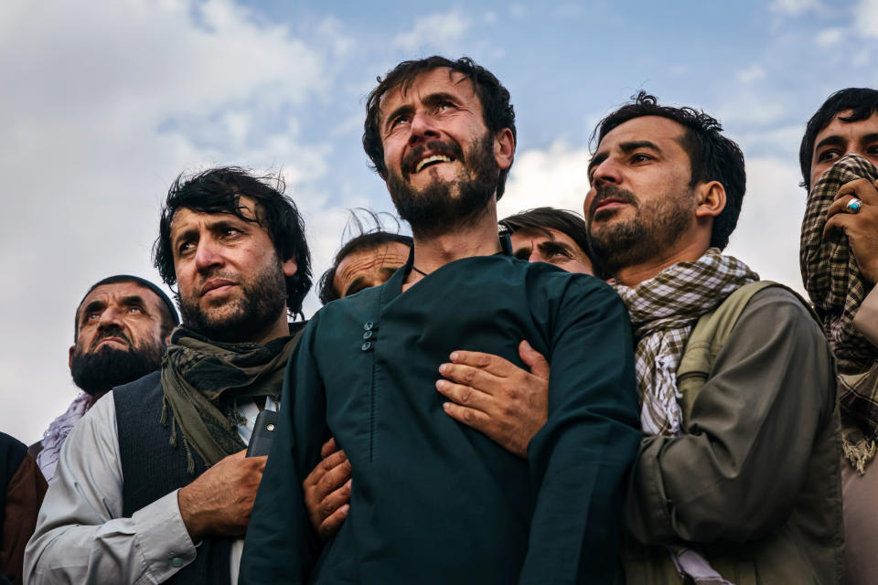 Image: Ramal Ahmadi is supported by family members during a mass funeral in Kabul on Monday. (Marcus Yam / Los Angeles Times via Getty Images)