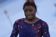 Simone Biles, of the United States, reacts after performing on the uneven bars during the women's artistic gymnastic qualifications at the 2020 Summer Olympics, Sunday, July 25, 2021, in Tokyo. (AP Photo/Gregory Bull)