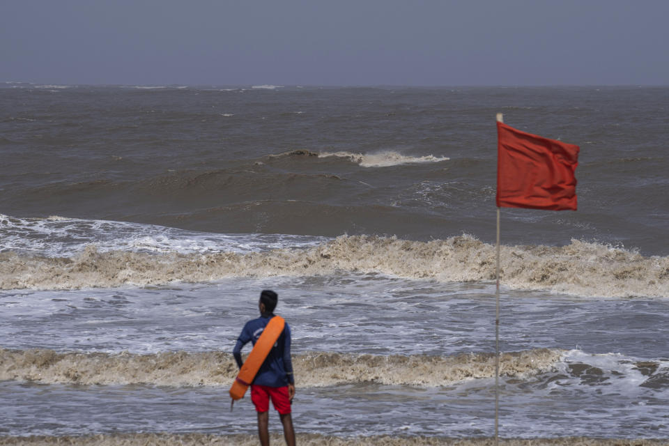 A lifeguard stands during high tide at a deserted Juhu beach on the Arabian Sea cost in Mumbai, India, Tuesday, June 13, 2023. India and Pakistan braced for the first severe cyclone this year expected to hit their coastal regions later this week, as authorities on Monday halted fishing activities, deployed rescue personnel and announced evacuation plans for those at risk. From the Arabian Sea, Cyclone Biparjoy is aiming at Pakistan's southern Sindh province and the coastline of the western Indian state of Gujarat. (AP Photo/Rafiq Maqbool)