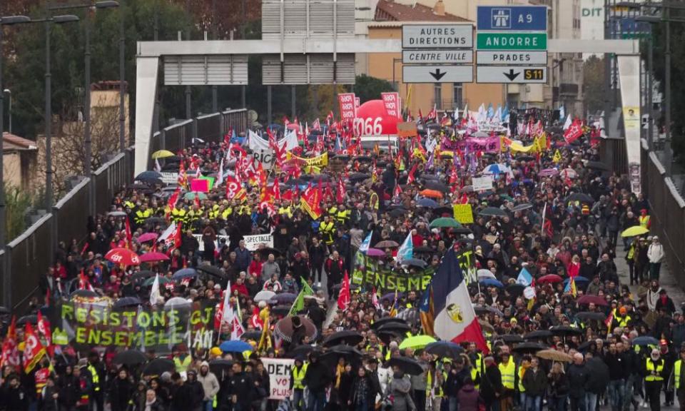 People holding flags and banners take part in a demonstration to protest against the pension overhauls, in Perpignan.