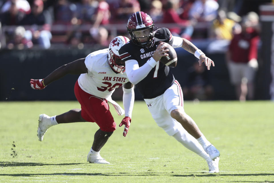 South Carolina quarterback Spencer Rattler (7) runs past Jacksonville State defensive lineman Jaylen Swain (30) during the second half of an NCAA college football game on Saturday, Nov. 4, 2023, in Columbia, S.C. (AP Photo/Artie Walker Jr.)