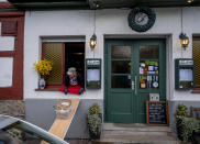 Food slides down to car from a window of the apple cider restaurant 'Zum Lahmen Esel' in Frankfurt, Germany, Friday, April 3, 2020. Due to the coronavirus outbreak the restaurant which has been in operation since 1807 offers cider and food to go in a self-made drive through set up. (AP Photo/Michael Probst)