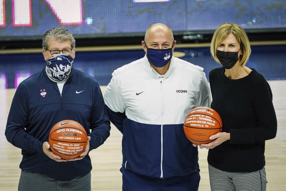 Connecticut director of athletics David Benedict presents a special game balls to head coach Geno Auriemma, left, and associate head coach Chris Dailey before an NCAA college basketball game against Marquette, Monday, March 1, 2021, in Storrs, Conn. (David Butler II/Pool Photo via AP)