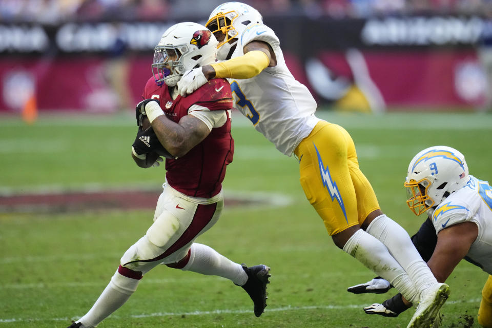 Arizona Cardinals running back James Conner (6) eludes the tackle of Los Angeles Chargers safety Derwin James Jr. during the second half of an NFL football game, Sunday, Nov. 27, 2022, in Glendale, Ariz. (AP Photo/Ross D. Franklin)