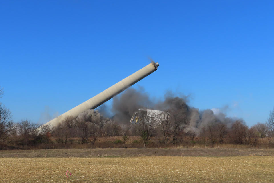 A former coal-fired power plant in Logan Township, N.J., collapses after explosives were detonated to implode it on Friday, Dec. 2, 2022. The plant was razed to make way for a battery facility to store energy from clean sources such as wind and solar. (AP Photo/Wayne Parry)