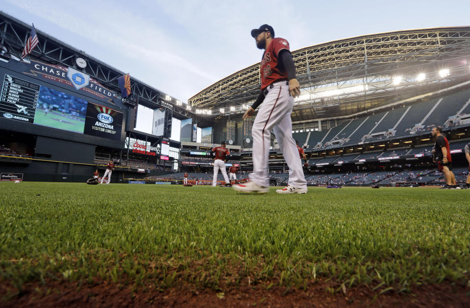 FILE - In this March 25, 2019, file photo, Arizona Diamondbacks' Steven Souza Jr. walks on new turf at the team's home field before an exhibition baseball game against the Chicago White Sox in Phoenix. Baseball's opening day isn't happening in Phoenix or anywhere else on Thursday as planned. The sport is on hold until at least mid-May while the world fights the coronavirus pandemic. If baseball does resume this season, there could be some radical scheduling solutions as MLB tries to squeeze in as many games as possible. (AP Photo/Elaine Thompson, File)