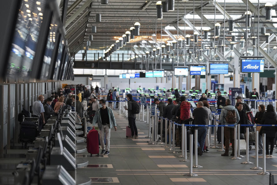 Passengers check in for flights at Vancouver International Airport after operations returned to normal after last week's snowstorm in Richmond, British Columbia, Monday, Dec. 26, 2022. (Darryl Dyck/The Canadian Press via AP)